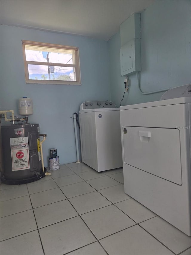 washroom featuring water heater, separate washer and dryer, and light tile patterned floors