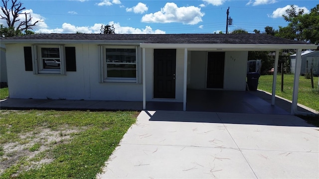 view of front facade featuring a carport and a front yard