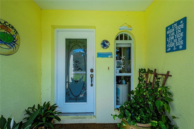 entrance to property featuring stucco siding