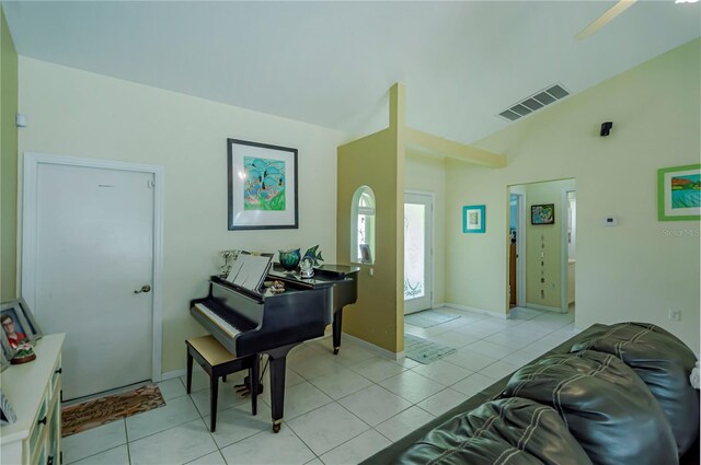 entrance foyer featuring baseboards, visible vents, light tile patterned floors, and vaulted ceiling