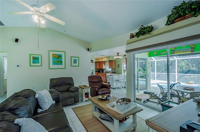 living room featuring a ceiling fan, lofted ceiling, and light tile patterned flooring
