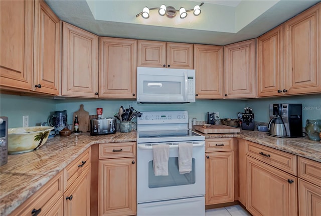 kitchen featuring white appliances, light brown cabinetry, and light stone countertops