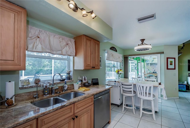 kitchen featuring sink, dishwasher, light stone counters, and plenty of natural light