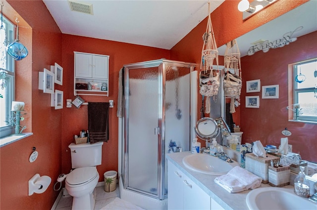 bathroom with a shower with door, vanity, toilet, and tile patterned flooring