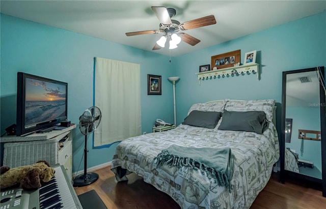 bedroom with a ceiling fan, baseboards, visible vents, and wood finished floors