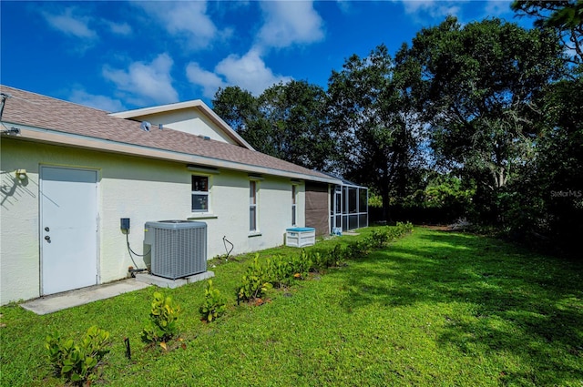 view of property exterior featuring a yard, cooling unit, glass enclosure, and stucco siding