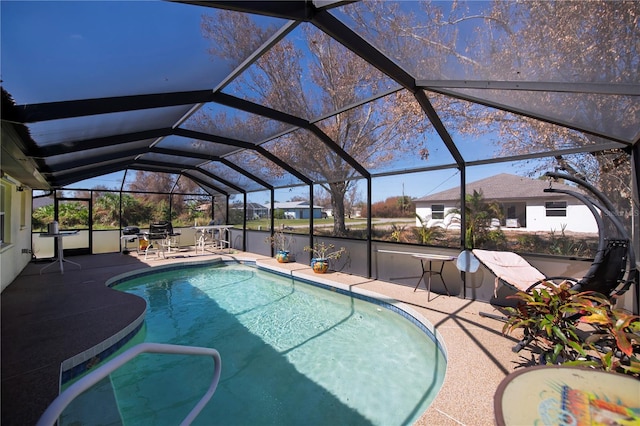 view of swimming pool featuring a patio and a lanai