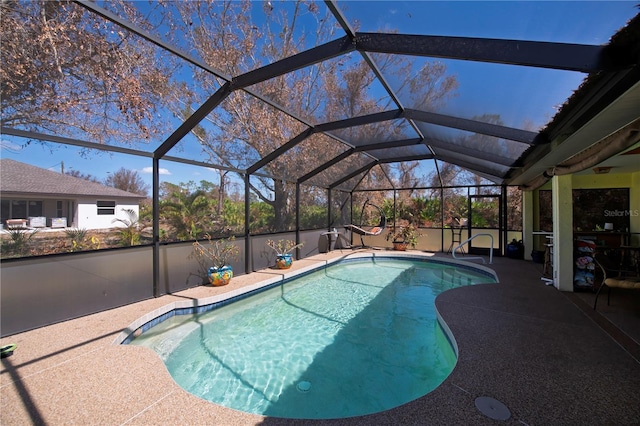 view of swimming pool featuring a patio area and a lanai