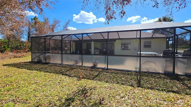 back of property featuring a yard, a swimming pool, and glass enclosure