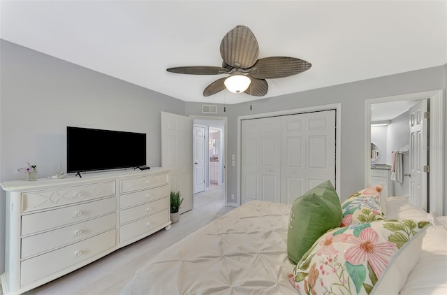 bedroom with ceiling fan, light colored carpet, and a closet