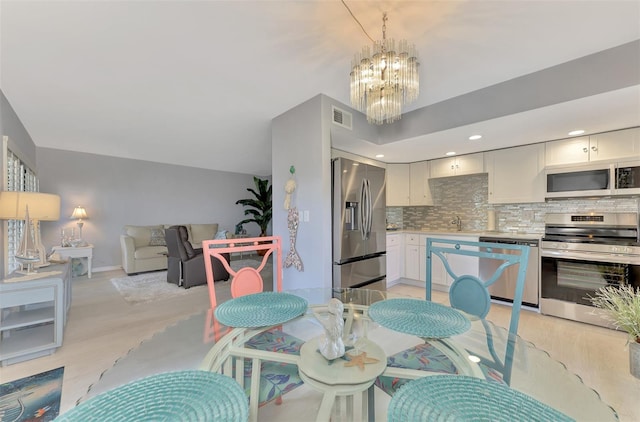 dining space featuring light hardwood / wood-style flooring and a chandelier