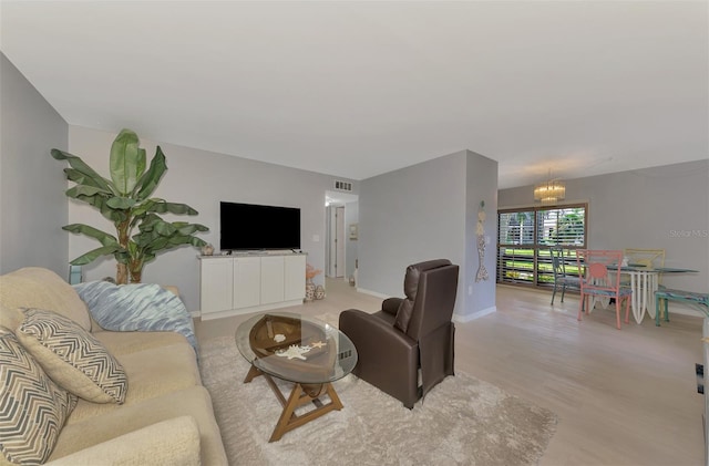 living room featuring light wood-type flooring and an inviting chandelier