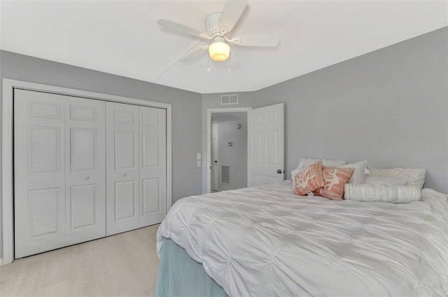 bedroom with light hardwood / wood-style flooring, a closet, and ceiling fan