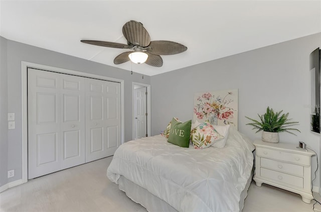 bedroom featuring light carpet, ceiling fan, and a closet