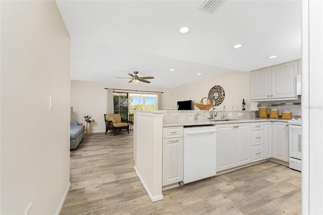 kitchen with white appliances, white cabinets, ceiling fan, light hardwood / wood-style floors, and kitchen peninsula