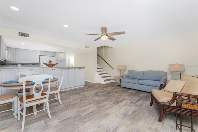 living room featuring light hardwood / wood-style floors and ceiling fan