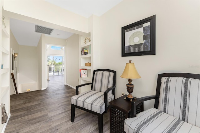 living area with built in features and dark wood-type flooring