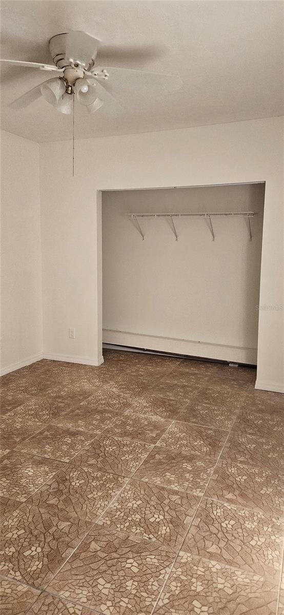 unfurnished bedroom featuring ceiling fan and a closet