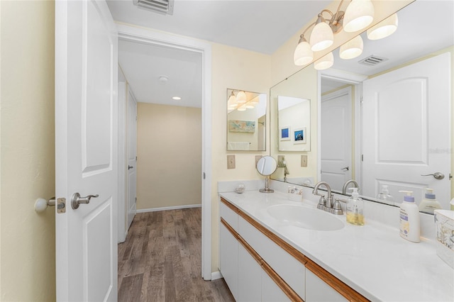 bathroom with hardwood / wood-style floors, vanity, and a notable chandelier