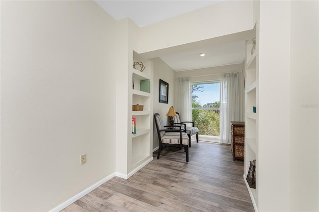 corridor featuring built in shelves and light hardwood / wood-style flooring