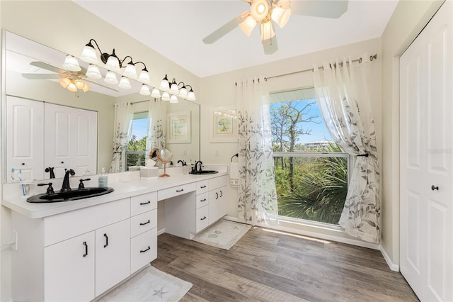 bathroom featuring ceiling fan, vanity, a healthy amount of sunlight, and hardwood / wood-style flooring