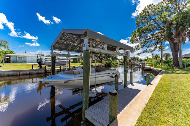 dock area featuring a water view, boat lift, and a lawn