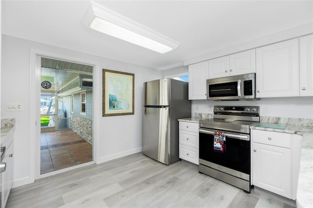 kitchen with stainless steel appliances, white cabinets, and light wood-style flooring