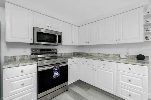 kitchen with white cabinetry, open shelves, and appliances with stainless steel finishes