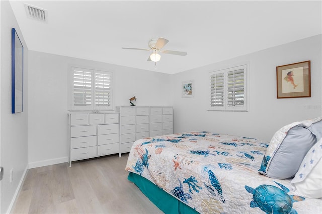 bedroom featuring ceiling fan, wood finished floors, visible vents, and baseboards