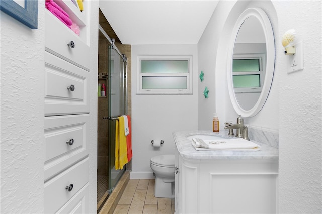 bathroom with wood finish floors, toilet, a stall shower, baseboards, and vanity