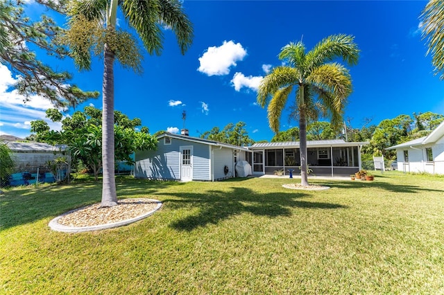 back of house with a lawn, fence, and a sunroom