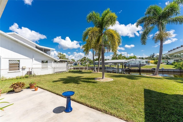 view of yard with fence, a patio, and a water view