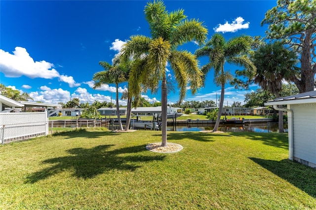 view of yard featuring fence and a water view