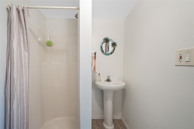 full bathroom with baseboards and a stall shower