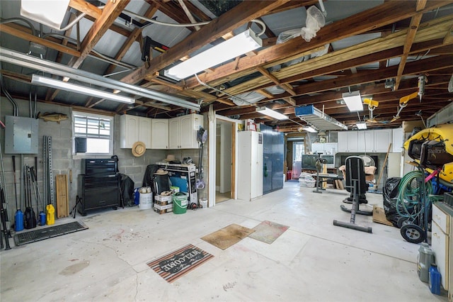 below grade area with electric panel, a garage, and concrete block wall