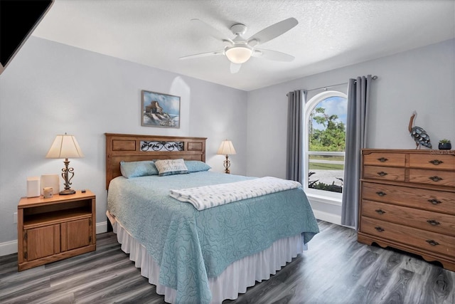 bedroom featuring a textured ceiling, dark hardwood / wood-style flooring, and ceiling fan