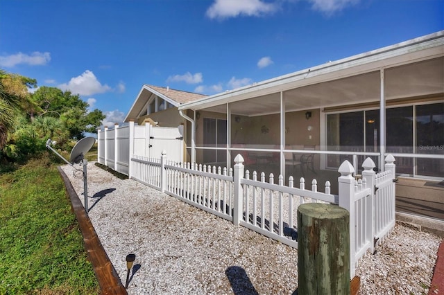 view of property exterior with a sunroom