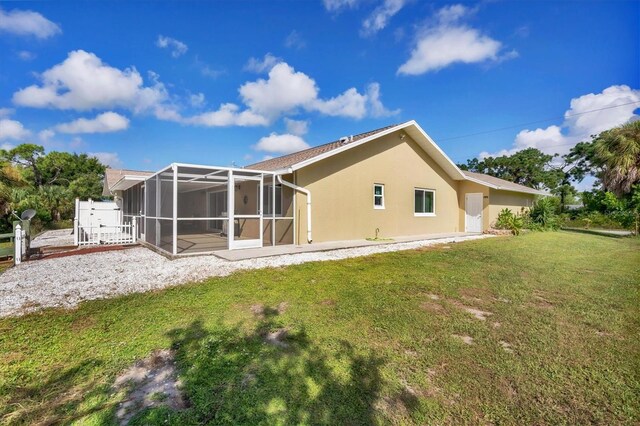 back of property with a lanai, a yard, and a patio area