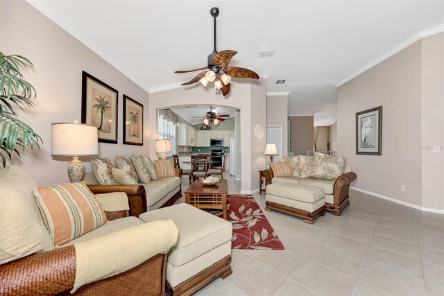 living room featuring light tile patterned floors, ornamental molding, and ceiling fan