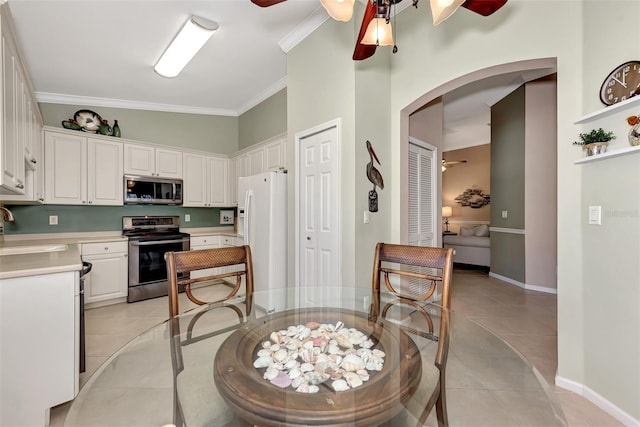 kitchen with ceiling fan, stainless steel appliances, light tile patterned floors, and white cabinets