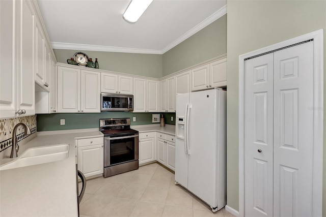 kitchen with sink, white cabinetry, stainless steel appliances, ornamental molding, and light tile patterned flooring