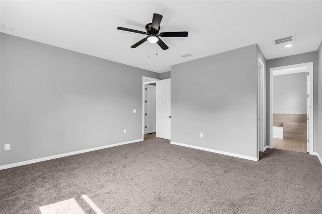 unfurnished bedroom with ensuite bath, ceiling fan, and carpet floors