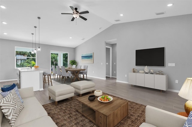 living room featuring vaulted ceiling, ceiling fan, hardwood / wood-style flooring, and sink