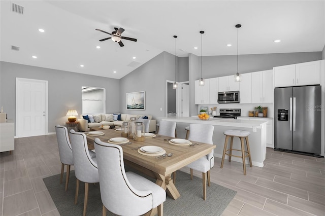 dining space featuring ceiling fan, light hardwood / wood-style flooring, and high vaulted ceiling