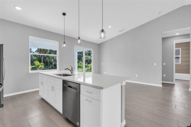 kitchen with white cabinets, dishwasher, a center island with sink, and sink