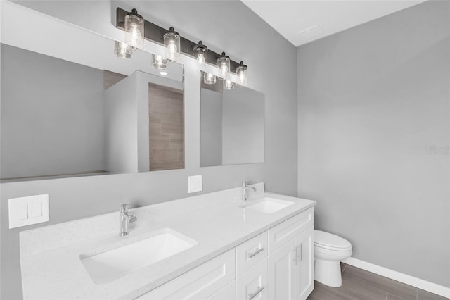 bathroom with vanity, toilet, and hardwood / wood-style flooring