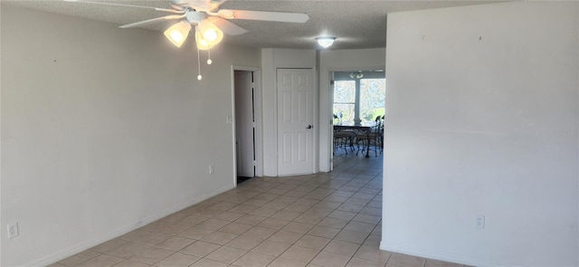 tiled empty room featuring a textured ceiling and ceiling fan