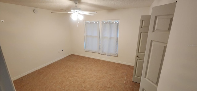 empty room with ceiling fan and a textured ceiling