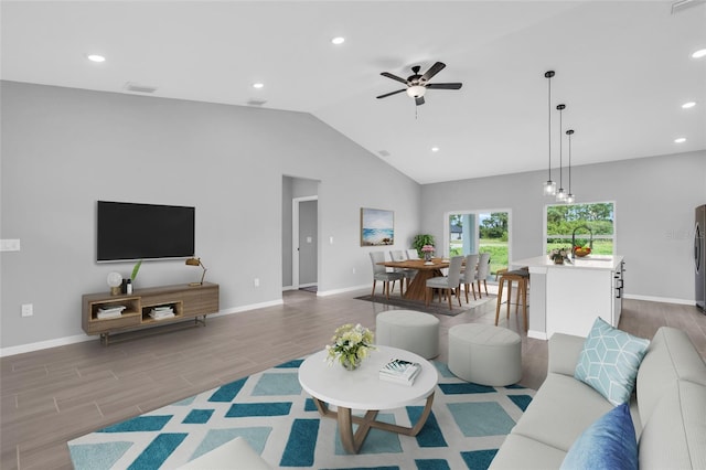 living room featuring hardwood / wood-style flooring, sink, high vaulted ceiling, and ceiling fan