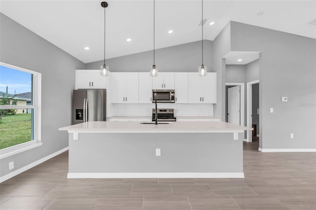 kitchen with appliances with stainless steel finishes, white cabinets, a center island with sink, and plenty of natural light